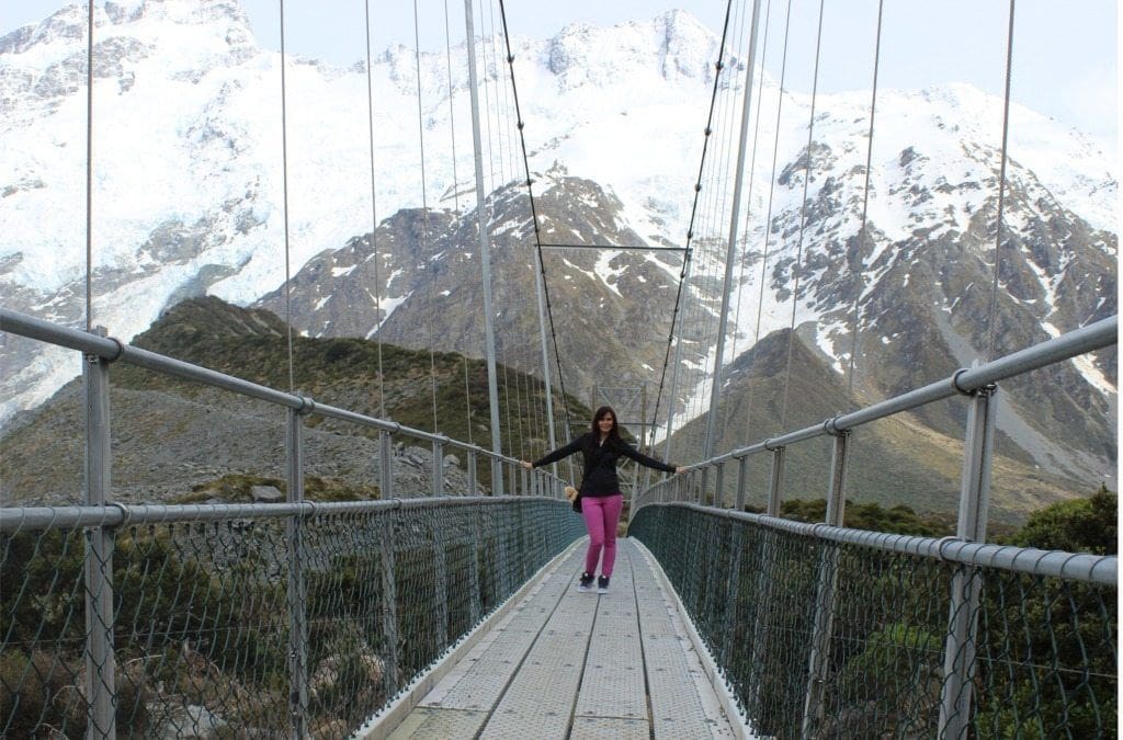 Louise on a bridge in New Zealand, wearing pink