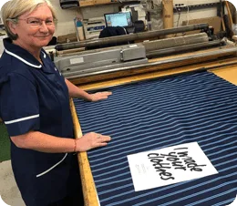 Keltic ties worker at a weaving machine preparing striped fabric, working for keltic as a custom made tie manufacturer
