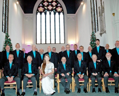 Choir uniform ideas: how loughborough male voice choir found its look | choir uniform ideas Loughborough male voice choir seated in a church wearing dark blazers and turquoise shirts